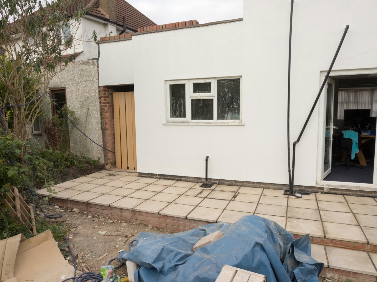 Residential building extension under construction with a new patio area.